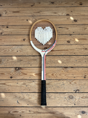 Raquette de tennis en bois vintage avec un coeur en mosaÏque argentée sur le cordage